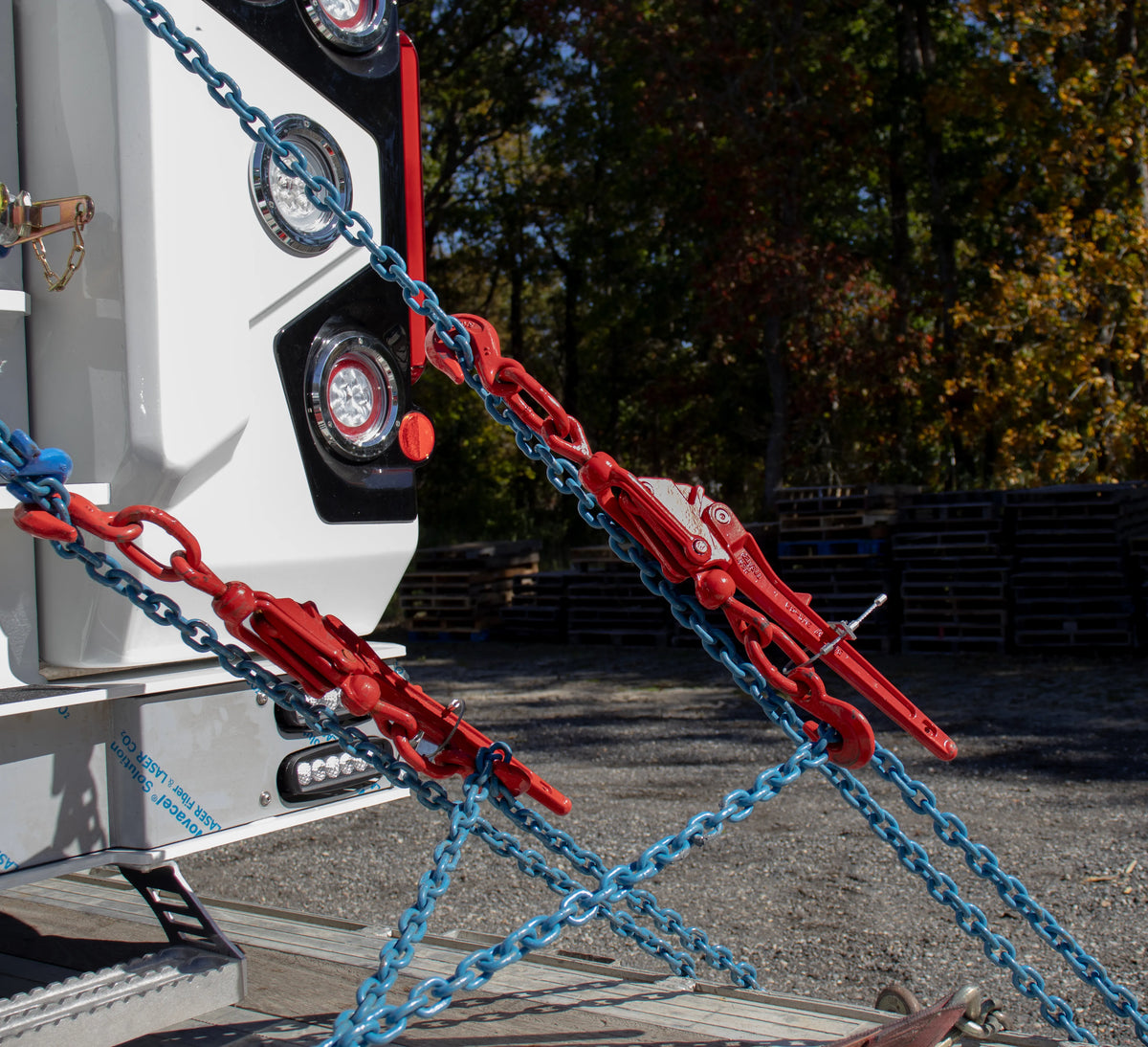 Ratchet binders and chains holding down an NRC wrecker body to a flatbed trailer