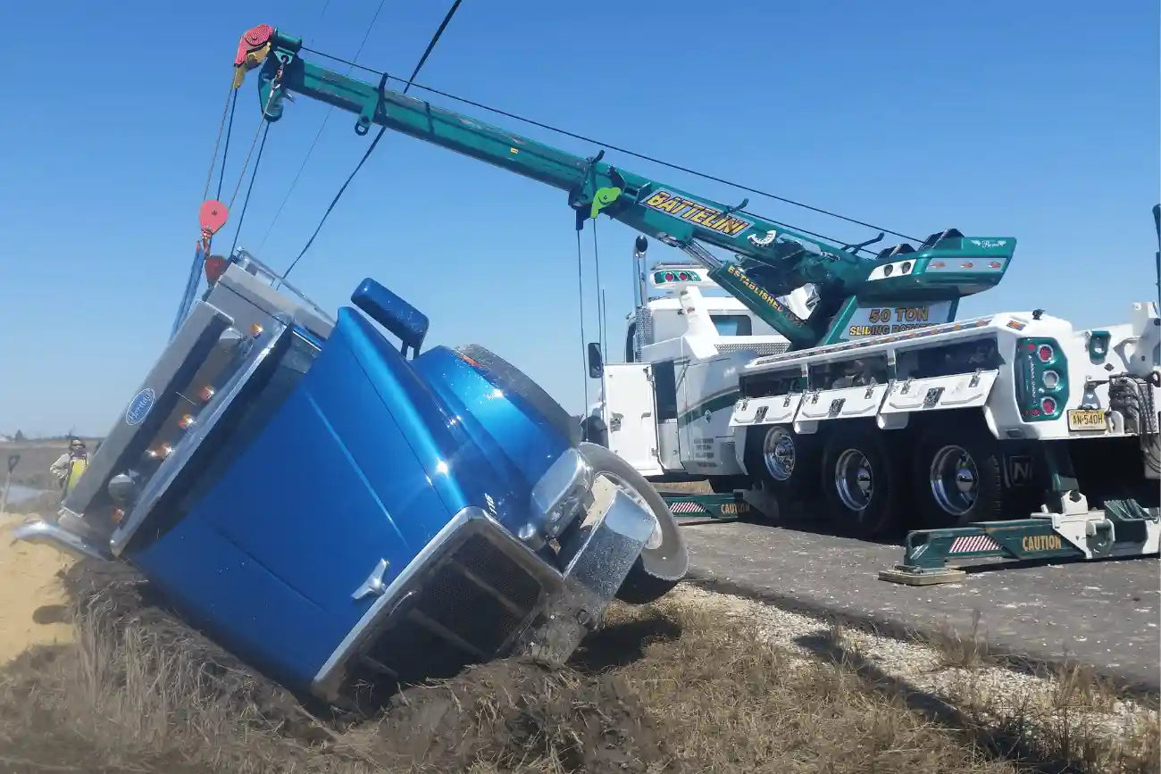 battelini heavy duty wrecker recovering a truck on the site of the road with it's boom extended