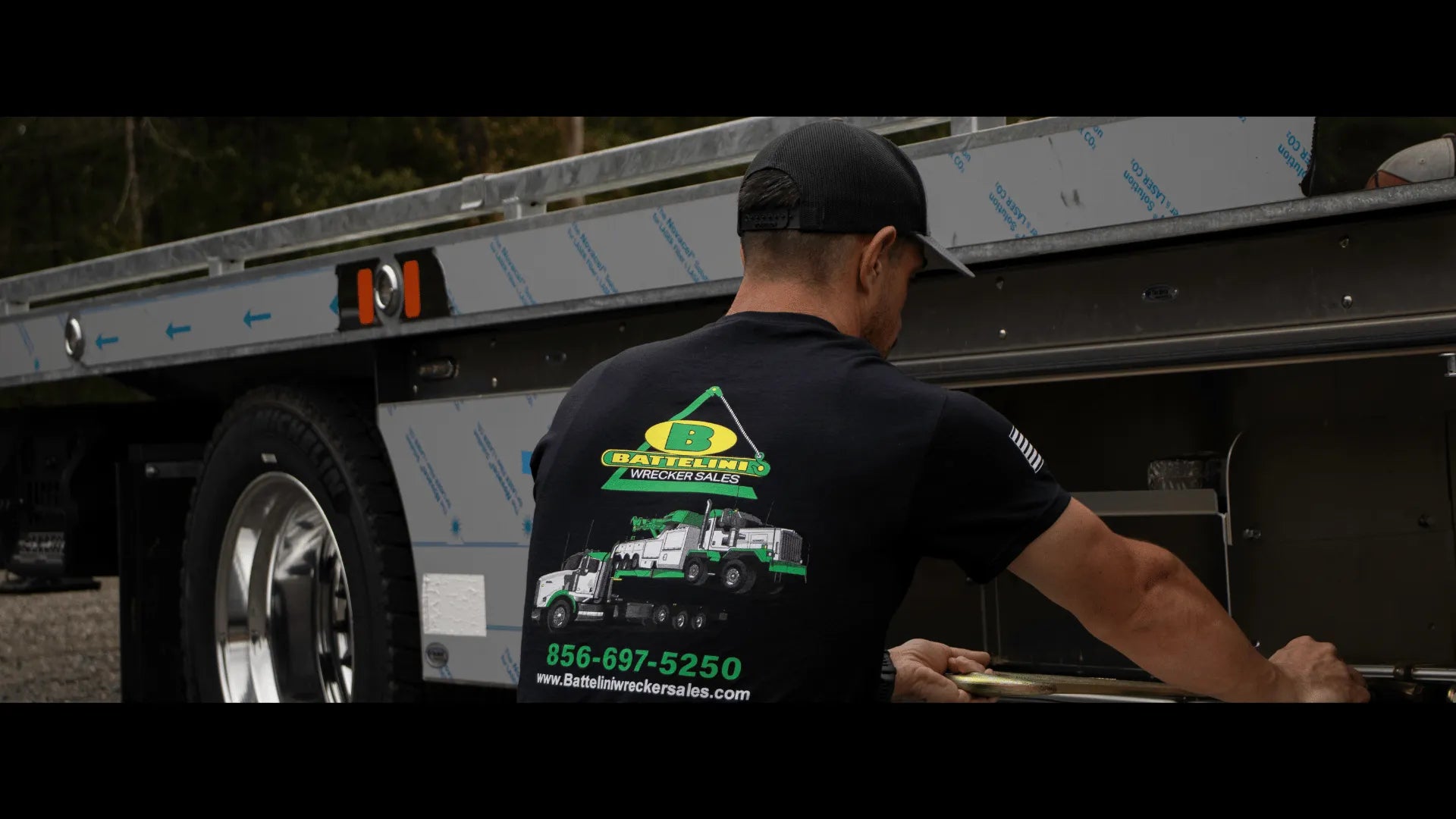 checking out a toolbox on a tow truck wearing Battelini's tow truck t-shirt
