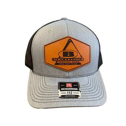 Grey front and black back trucker hat with sewn leather Battelini logo