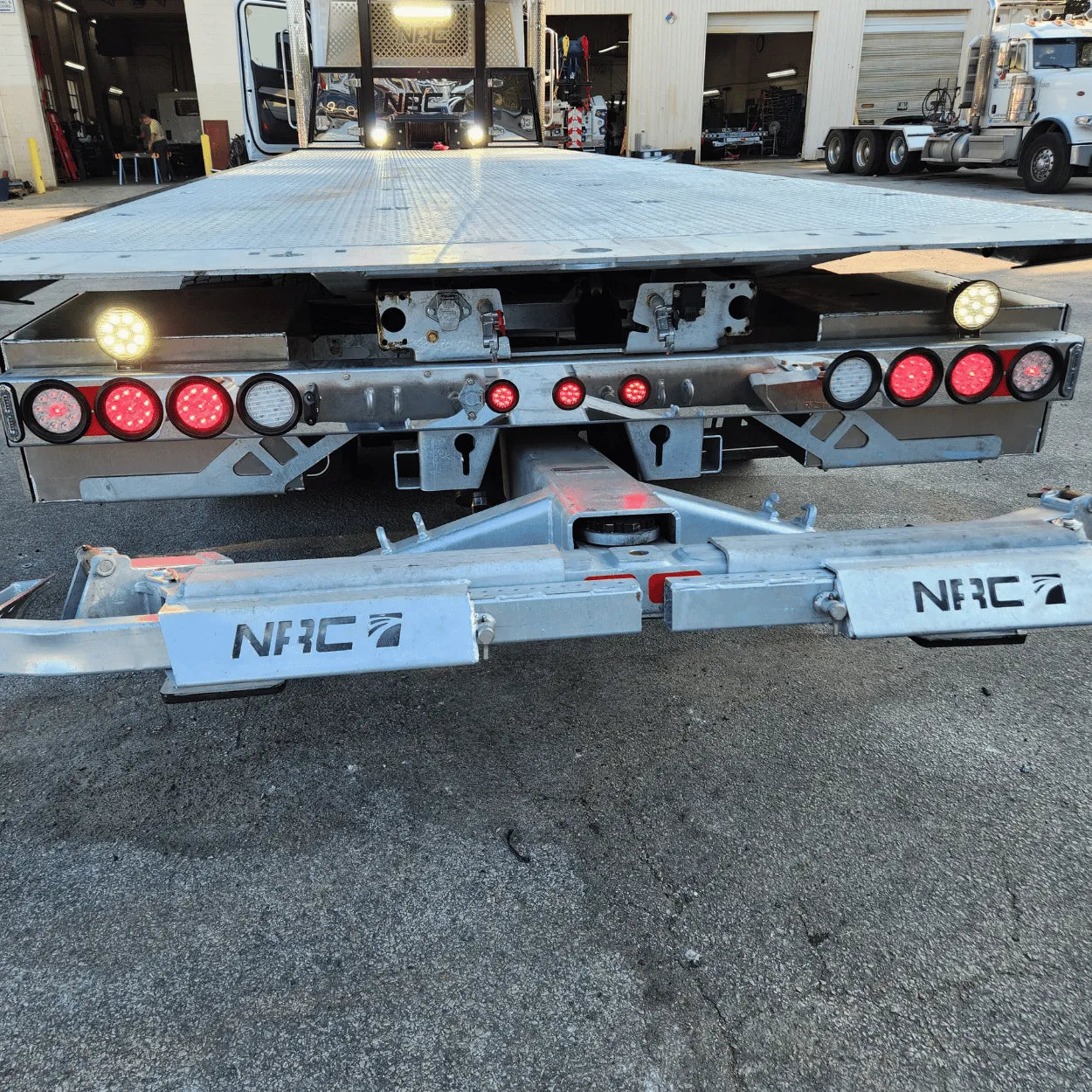 a close up of the rear of an nrc car carrier rollback highlighting the led truck lights