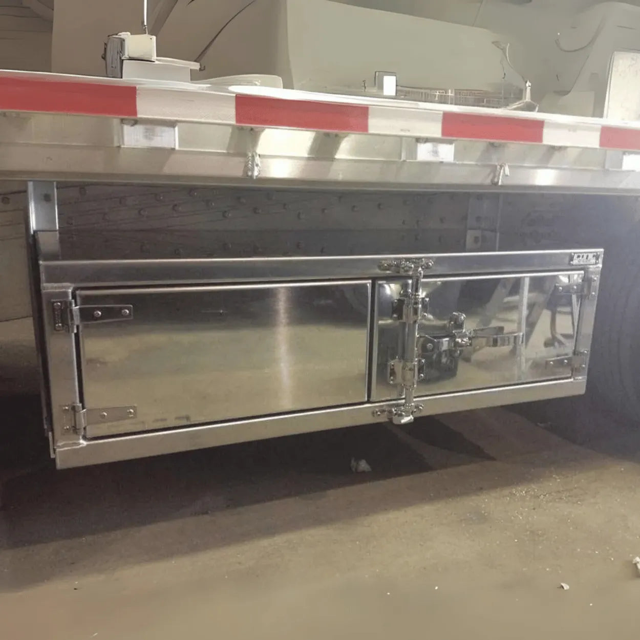 Premium underbody toolbox with a polished finish and camlock system, ideal for rollback tow trucks and trailers. Secure and sleek storage.