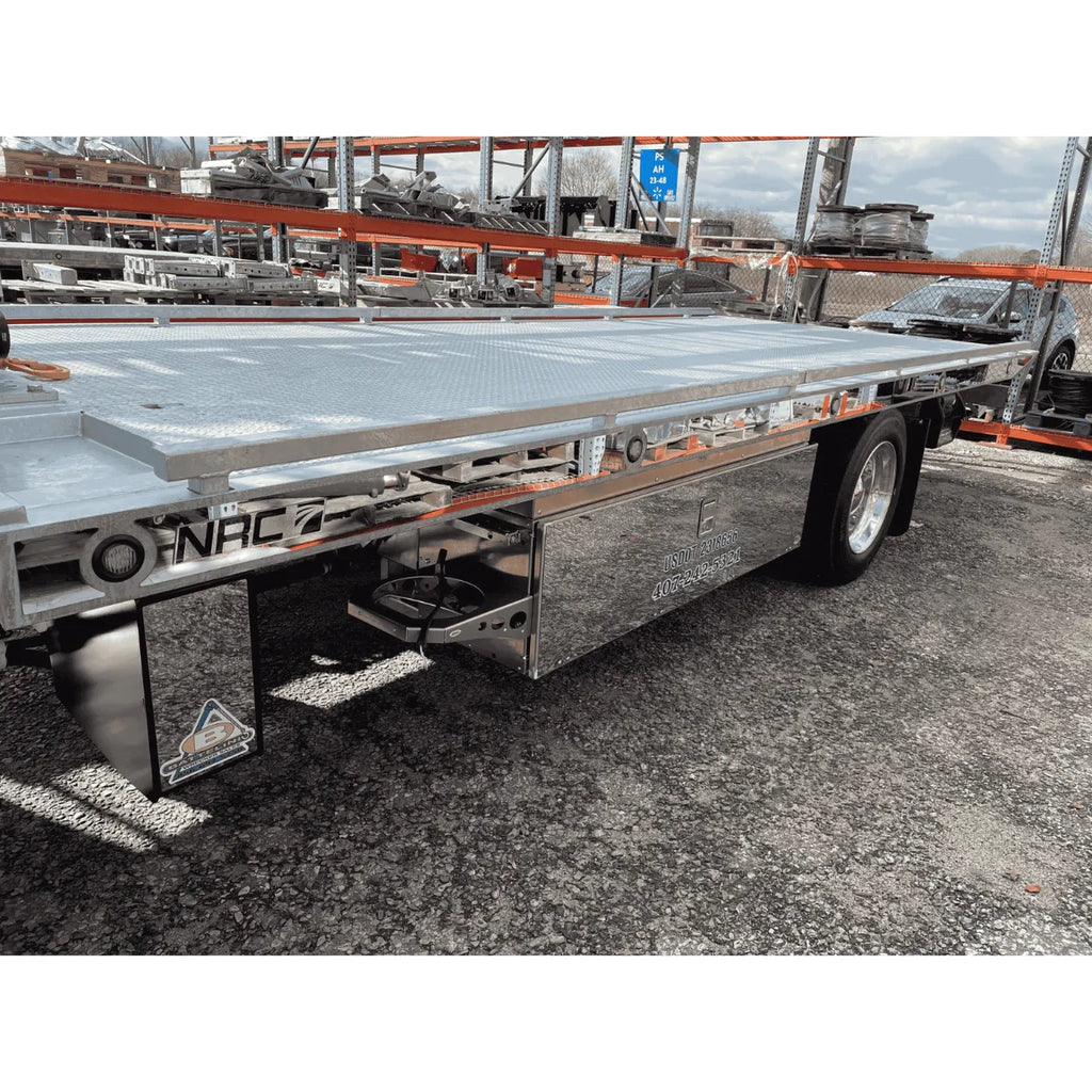 Close-up of NRC galvanized carrier deck side rail with NRC logo cutout, marker light, and stainless toolbox