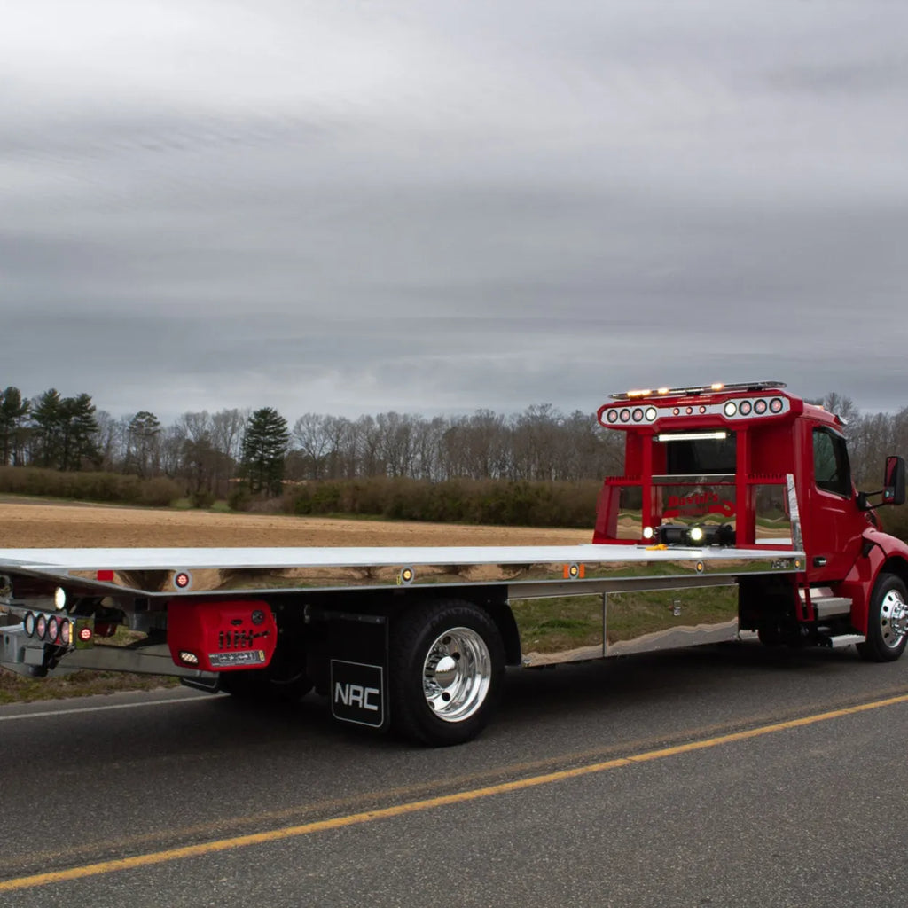 Red NRC car carrier with polished stainless steel deck side trim, LED marker lights, and stainless toolboxes