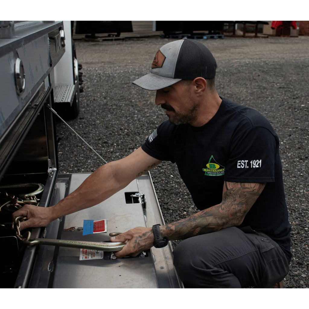 pulling chain out of a toolbox wearing Battelini trucking t-shirt