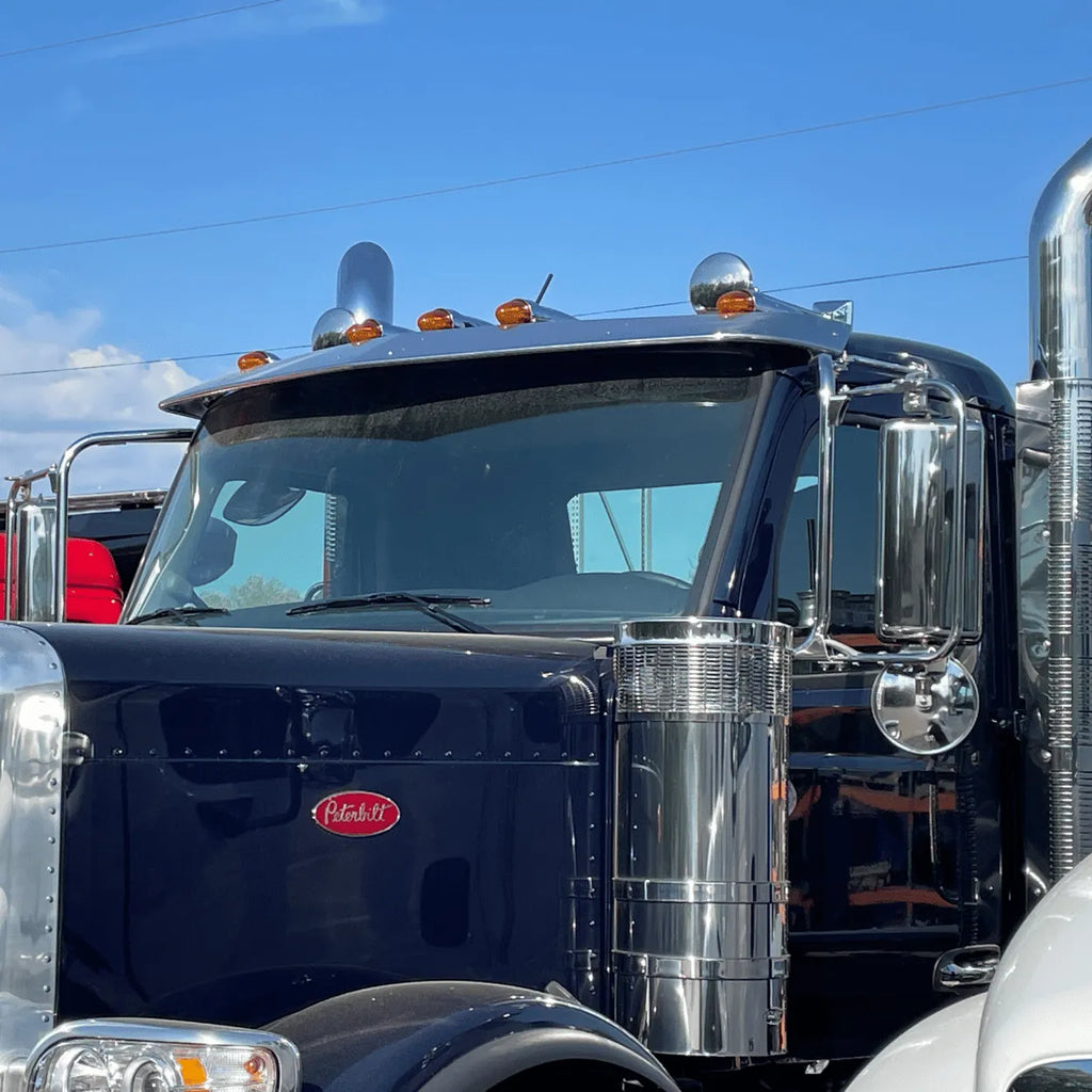 Stainless steel sunvisor mounted on Peterbilt 589 truck cab, model R73-6056, showing polished chrome finish and aerodynamic design