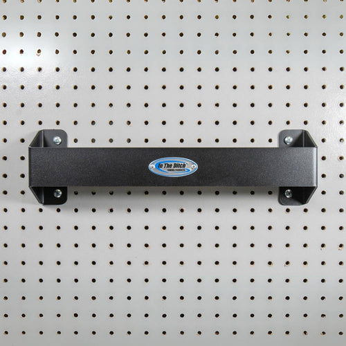 In The Ditch Tie Down Strap Hanger mounted on a pegboard. Black powder-coated aluminum hanger for organizing tie downs and chains in toolboxes or garages.