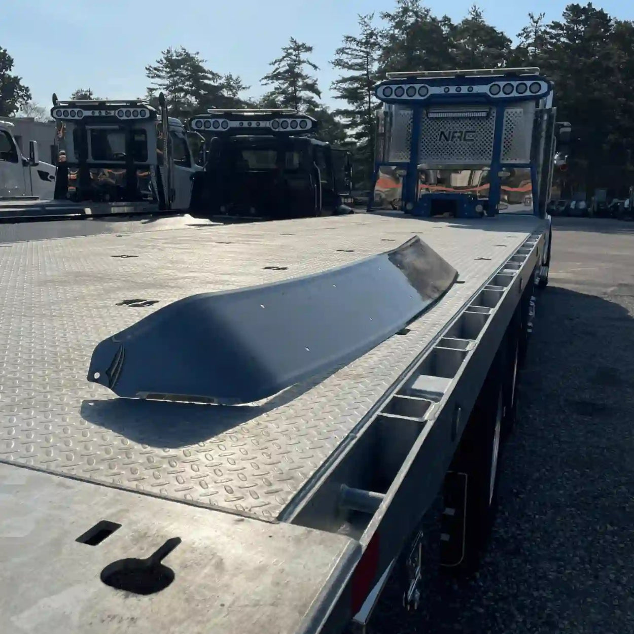 Exterior Stainless Steel Western Star Visor C604  sitting on the bed of a car carrier - 22-64880-000